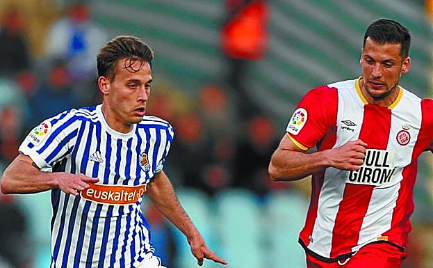 Canales conduce el balón perseguido por Granell. 