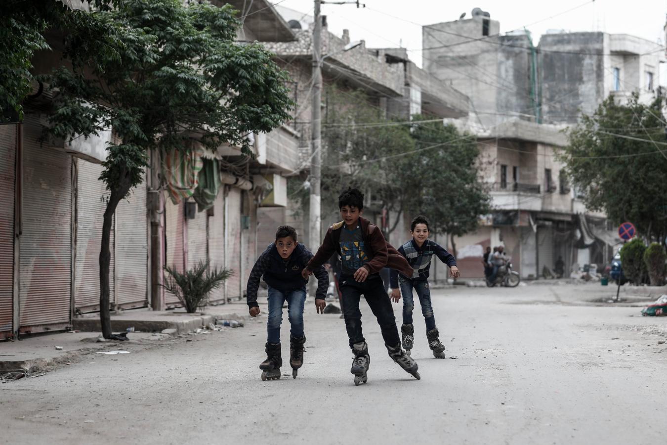Cualquier lugar es bueno para divertirse, aunque la situación no acompañe. En las imágenes, un grupo de jóvenes sirios disfruta patinando.