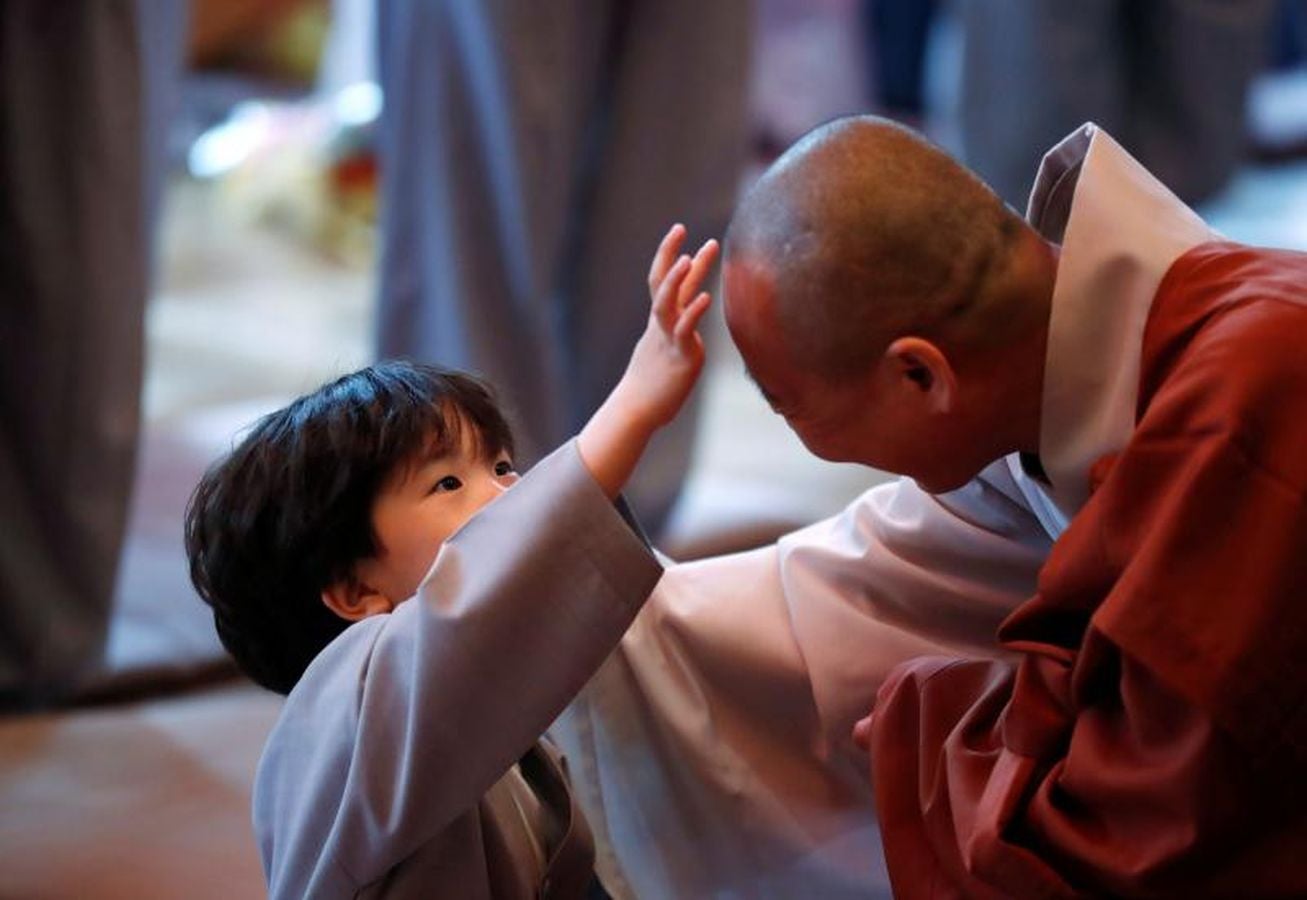 Los monjes principiantes caminan bajo linternas de loto con peticiones de oración cuando se van después de un evento para celebrar el próximo Día de Vesak, el cumpleaños de Buda, en el templo Jogye en Seúl, Corea del Sur, 2 de mayo de 2018.