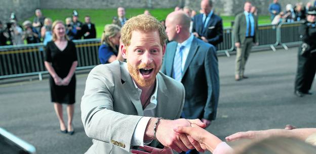 El príncipe Enrique estrecha las manos de incondicionales apostados ante los accesos al castillo de Windsor. 