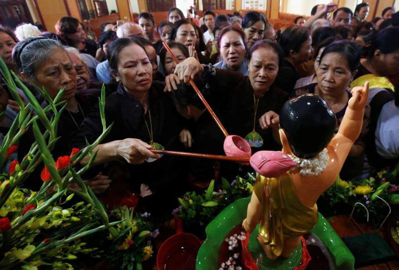 Los vietnamitas budistas vierten agua perfumada mientras bañan estatuas del niño Buda durante las celebraciones del 'VosakÊDay' que conmemora el nacimiento, la iluminación y el ingreso del Buda al Nirvana en la pagoda Quan Su, en Hanoi, Vietnam. 