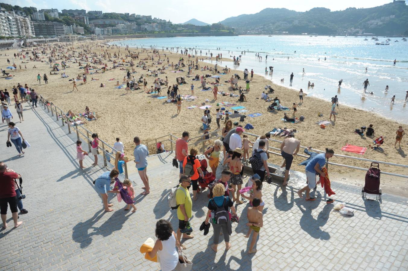 Los donostiarras han aprovechado los rayos de sol de la jornada para pasear por la playa