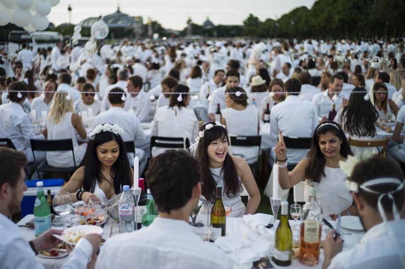 Miles de personas vestidas de blanco comparten una cena en Inválidos durante la 30ª edición de la cena en blanco 'Diner en Blanc' en París.