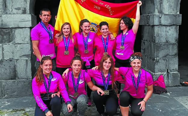 Txapeldunak. Las Bateleras, junto a su entrenador Anartz Gereño, con la bandera lograda en Castro.