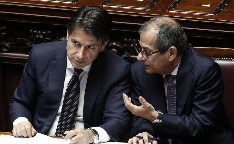 El primer ministro italiano, Giuseppe Conte (izq), conversa con su ministro de Economía, Giovanni Tria.