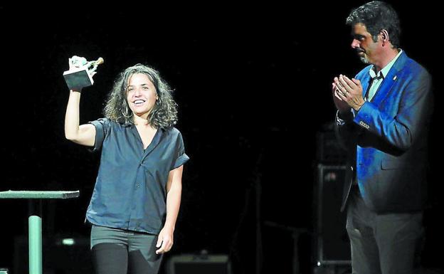 Anari muestra el Adarra Saria tras recibirlo del alcalde donostiarra, Eneko Goia, anoche en el teatro Victoria Eugenia. 