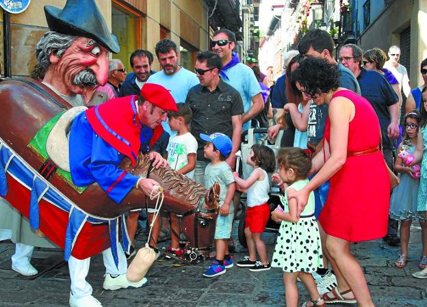 Un zaldiko y un cabezudo de la comparsa de gigantes y kilikis se arriman de forma amistosa a unos niños temerosos.