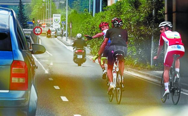 Un vehículo adelanta a tres ciclistas en una vía de Donostia.