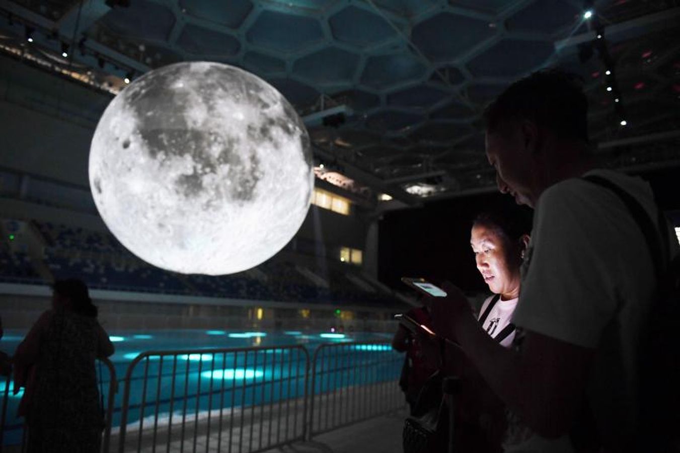 Un modelo de la Luna cuelga sobre la piscina olímpica en el Centro Aquático Nacional en Pekín, en China.