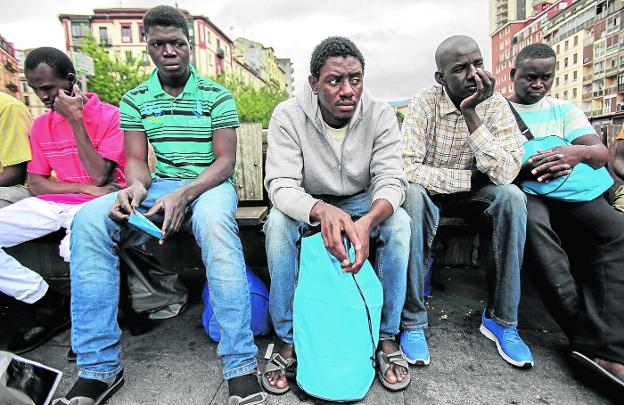 Un grupo de migrantes espera reanudar su tránsito hacia Europa en una plaza de Bilbao.