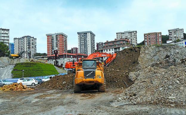 Una excavadora trabaja en relleno de tierras.