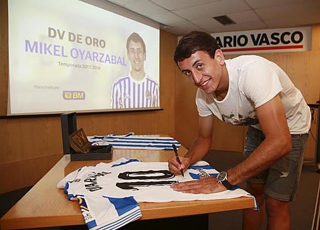 Oyarzabal firma dos de las nuevas camisetas con el dorsal '10' a la espalda, que serán sorteada entre los suscriptores del club DV, ayer en un momento del acto.