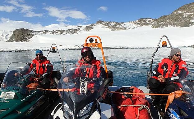 Imagen principal - Iñaki y sus compañeros, con unas motos de agua. Debajo, imagen de los contenedores donde habitaban antes de construir la base nueva. A la derecha, realizando tareas habituales en el glaciar.