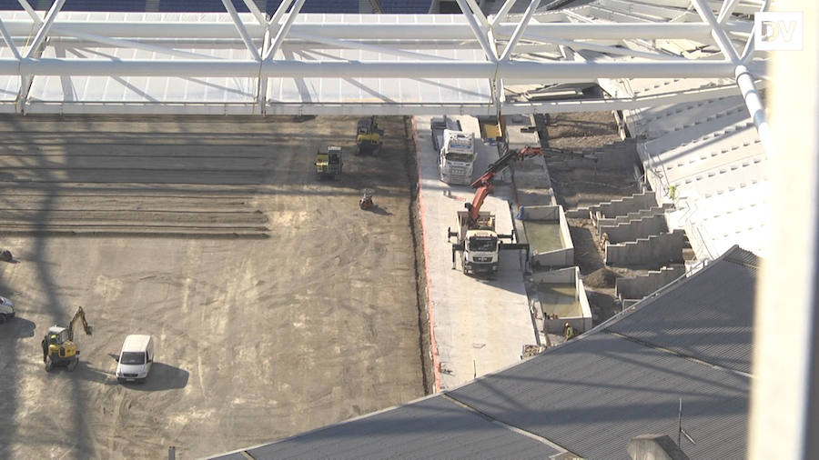 Los operarios trabajan en el terreno de juego adecuarlo y colocar el césped 