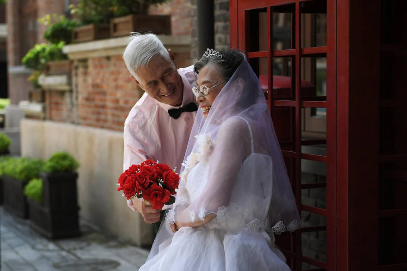 Parejas mayores que lleven más de 50 años casadas posan durante un evento para recrear las fotos de boda por el festival Qixi, el San Valentín chino, en Tianjin.