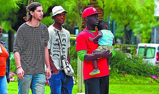 Un migrante sostiene al niño Mali de Costa de Marfil, que con su madre y su hermana irán ahora a Vitoria.