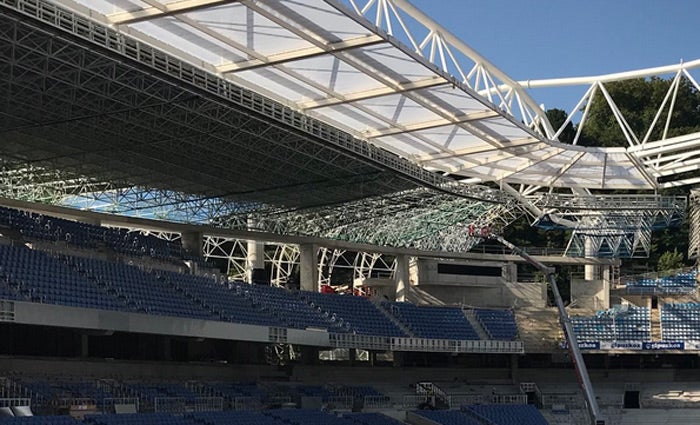 Desde la zona inferior de la grada Este se ve cómo queda el material azul que recubrirá el estadio, ya colocado parcialmente sobre la grada Sur (Luis Azkune).