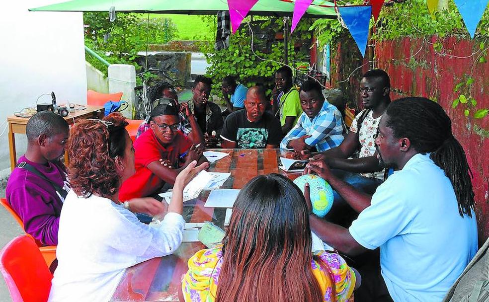 Tres voluntarios imparten una clase de castellano para los migrantes que pasan por Lakaxita. La mayoría solo habla francés y muchos no saben leer.