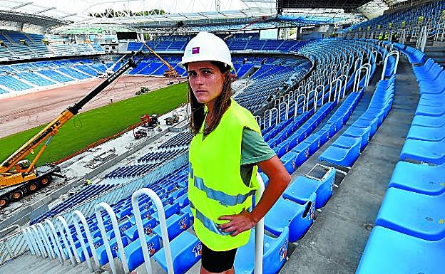 La capitana del equipo femenino de la Real Sociedad, Sandra Ramajo, en la tribuna principal de Anoeta mientras operarios instalan los tepes de césped.