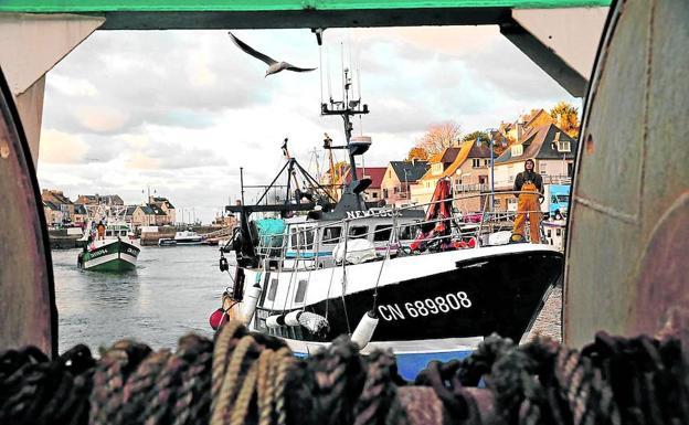 Pesqueros galos regresan de los caladeros al puerto de Bessin-Huppain. Abajo, izado de las redes cargadas de moluscos y un enfrentamientro de británicos y normandos en el mar