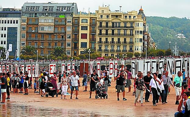 Los participantes en la protesta contra la incineradora recorren la playa de La Concha. 