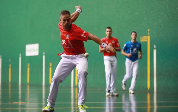 Aimar Olaizola arma el brazo para golpear de derecha ayer en el Jostaldi de Hondarribia. Al fondo, Ander Imaz y Jon Ander Albisu. 