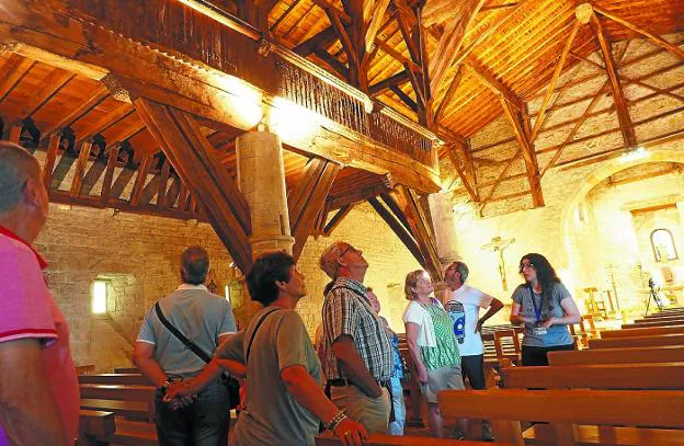 Antigua. Turistas admirando el entramado de madera del interior de la ermita.
