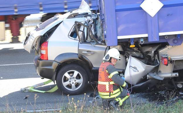 El coche ha quedado empotrado bajo el camión. 