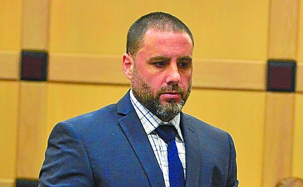 Pablo Ibar, esposado, porta unos documentos en la sala de vistas. 