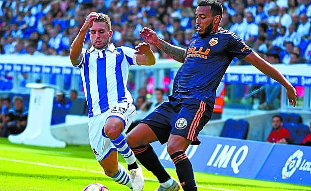Kevin trata de ganar el balón para progresar por su banda izquierda ante la oposición de Vezo ayer en Anoeta.