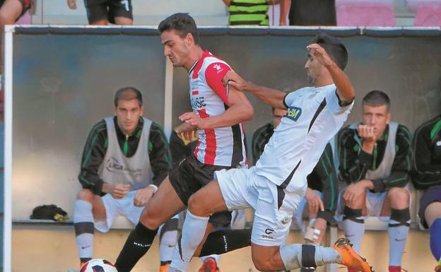 El irundarra Eizmendi trata de frenar el avance de un jugador riojano sobre el césped de Las Gaunas.