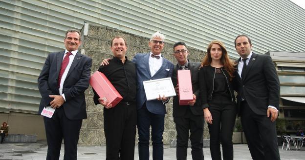 José Carlos Román, con pajarita y el diploma, posa flanqueado por los otros dos finalistas y miembros del jurado. 