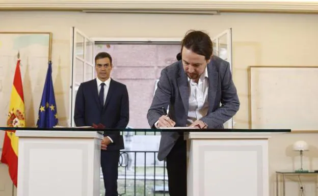 El secretario general de Podemos, Pablo Iglesias, firma el acuerdo para los presupuestos junto al presidente Pedro Sánchez.