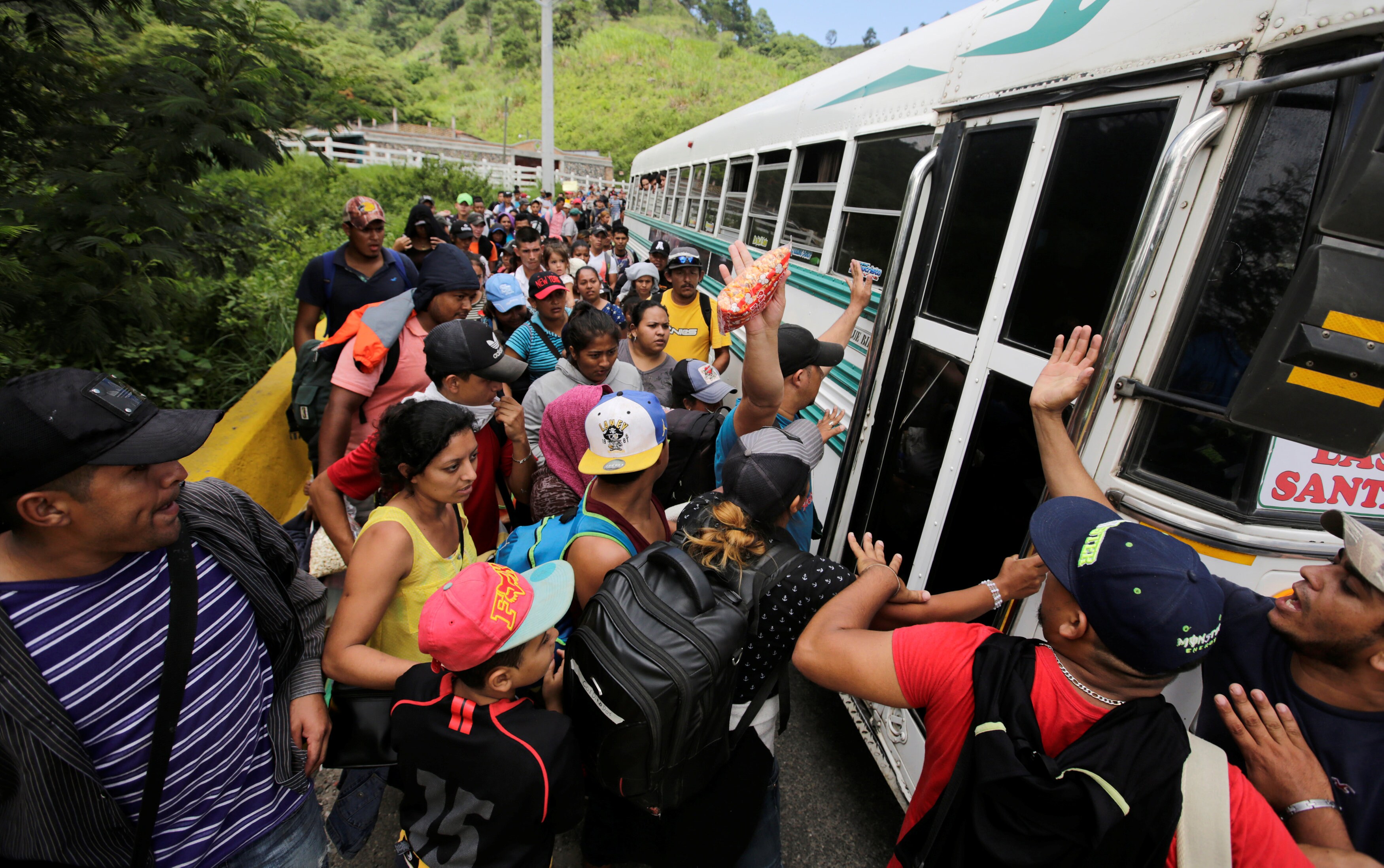 Cientos de hondureños hacen cola para coger una caravana que les lleve a Estados Unidos.