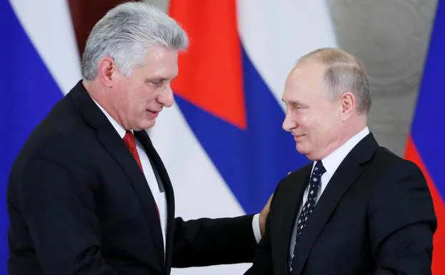 Díaz-Canel (i) y Putin se dan la mano. 