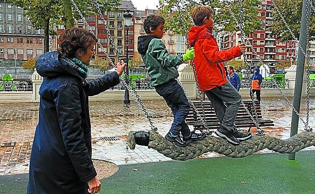 Imagen principal - Rosa Martínez con sus hijos; Eneko Andueza en el despacho y Oskar Matute preparando la mochila de su hijo. 