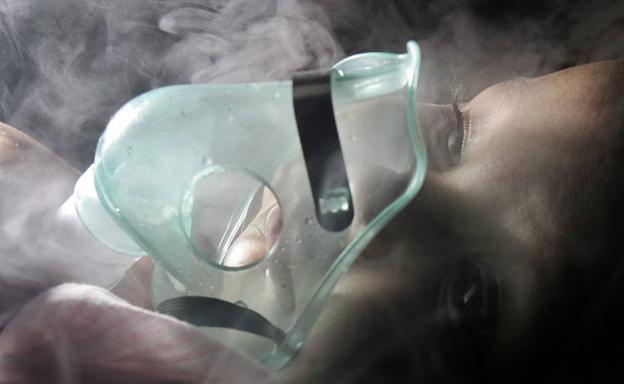 Una niña enferma de neumonía recibe tratamiento con una mascarilla de óxigeno en Honduras.