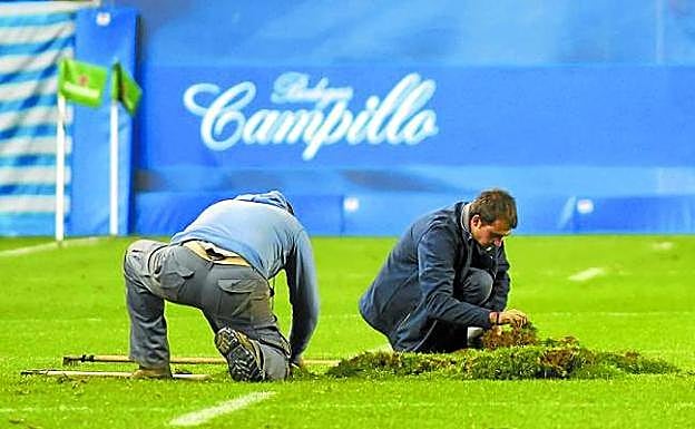 Operarios devuelven a su sitio parte de un tepe de césped desprendido el sábado en Anoeta 