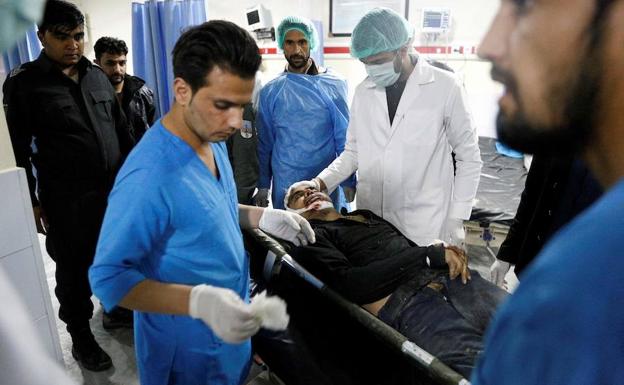 Médicos afganos junto al cadáver de un hombre tras el ataque.