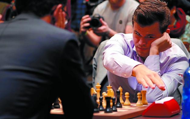 Carlsen pulsa el cronómetro tras ejecutar una jugada ante la mirada de Caruana en la final de ayer. 