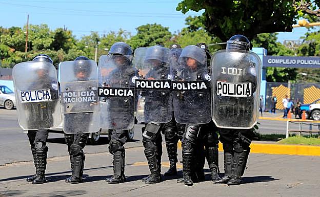 Oficiales de la policía antidisturbios montan guardia frente a la sede de la policía en Managua, Nicaragua.