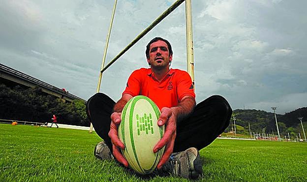 Oskar Astarloa sujeta con sus manos el balón oval en el campo de rugby.