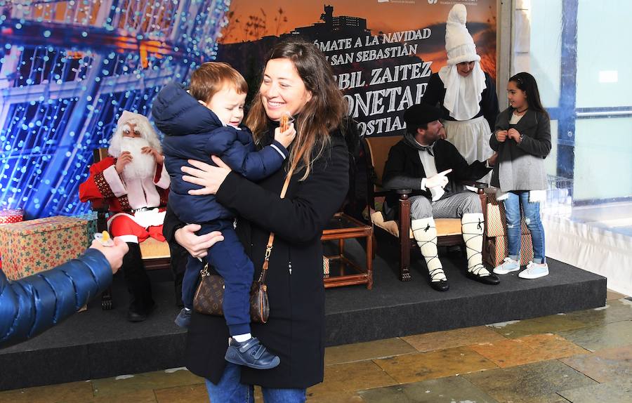 Papa Noel, Olentzero y Mari Dominguí recibieron ayer en la plaza Okendo de San Sebastián a los niños que se acercaban con sus cartas de peticiones.