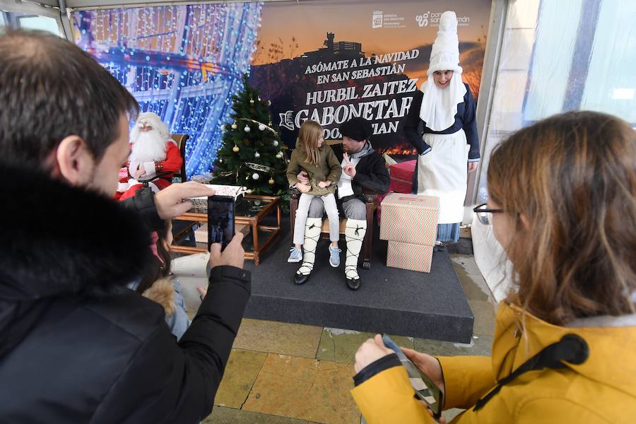 Papa Noel, Olentzero y Mari Dominguí recibieron ayer en la plaza Okendo de San Sebastián a los niños que se acercaban con sus cartas de peticiones.