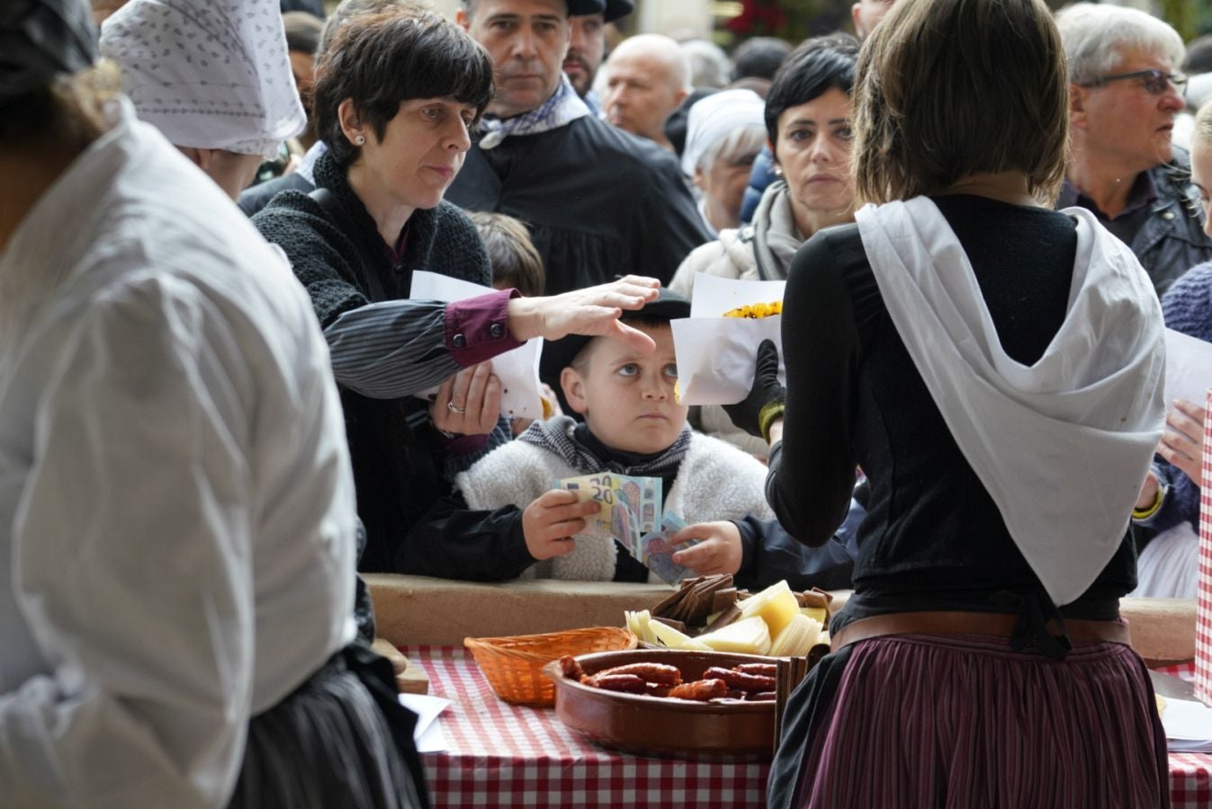 Gran ambiente en las calles de San Sebastián. Niños y mayores disfrutan de Día de Santo Tomás entre talos y txistorra.