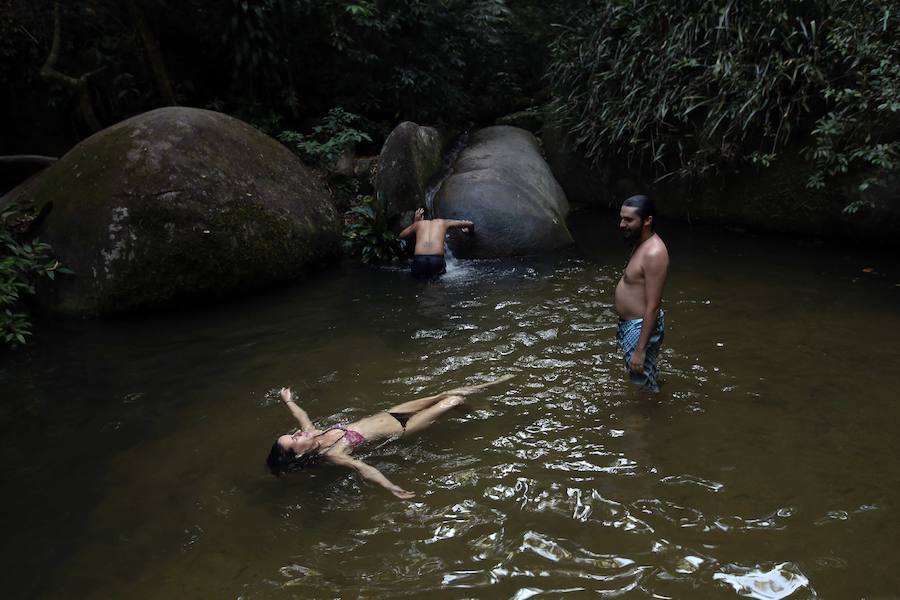 Ya ha comenzado ell verano austral. Pero las playas de Río de Janeiro ya están llenas de bañistas desde hace unas semanas. Y es que el calor aprieta. El martes los termómetros alcanzaron 40,7 grados en la zona oeste de la ciudad, en el que ha sido el día más caluroso en varios años, con una sensación térmica de 45 grados. El mar está calmado y apenas hay olas en las transparentes aguas. Las imágenes han sido tomadas en la Floresta de Tijuca, el bosque urbano más grande del mundo, y en los arenales del oeste de Río.