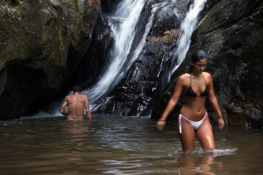 Ya ha comenzado ell verano austral. Pero las playas de Río de Janeiro ya están llenas de bañistas desde hace unas semanas. Y es que el calor aprieta. El martes los termómetros alcanzaron 40,7 grados en la zona oeste de la ciudad, en el que ha sido el día más caluroso en varios años, con una sensación térmica de 45 grados. El mar está calmado y apenas hay olas en las transparentes aguas. Las imágenes han sido tomadas en la Floresta de Tijuca, el bosque urbano más grande del mundo, y en los arenales del oeste de Río.