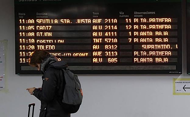 Un usuario consulta los trenes cancelados en la estación de Atocha.