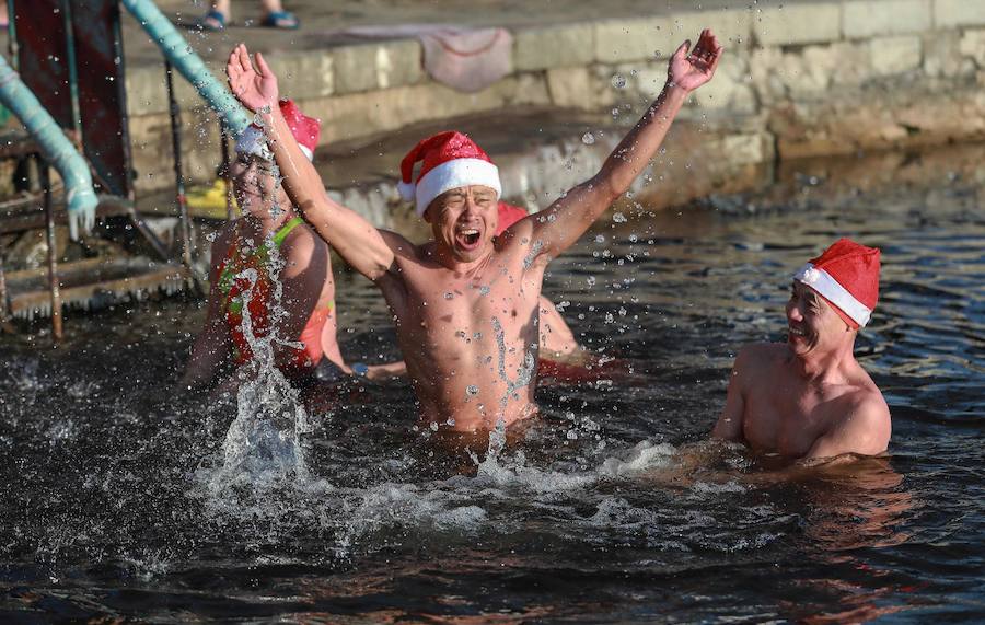 Entusiastas de la natación de invierno con sombreros de Santa Claus nadan en temperaturas de menos 21 grados centígrados (-6 F) en Shenyang, en la provincia de Liaoning, noreste de China.
