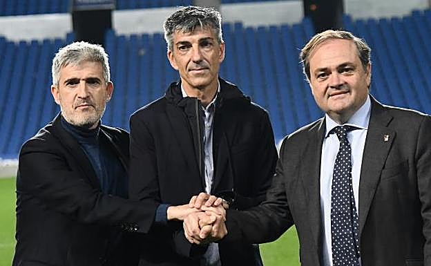 El director de fútbol, Roberto Olabe, Imanol Alguacil y el presidente, Jokin Aperribay, estrechan sus manos sobre el césped de Anoeta.